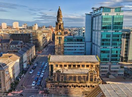 Aerial view of Glasgow city centre around St George's Tron Church, with the city skyline beyond