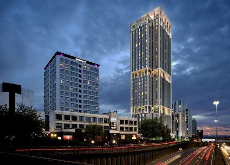 A modern residential tower in Glasgow, lit at dusk